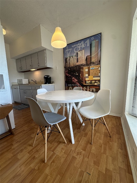 3316 Guadalupe Street, Unit 306 Austin, TX 78705 - Photo 23 of 28 a view of a dining room with furniture and wooden floor