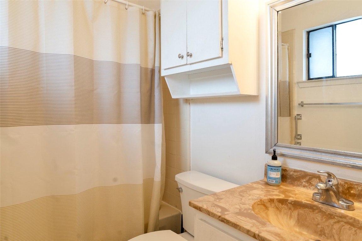 3316 Guadalupe Street, Unit 306 Austin, TX 78705 - Photo 8 of 28 a bathroom with a granite countertop sink and a mirror