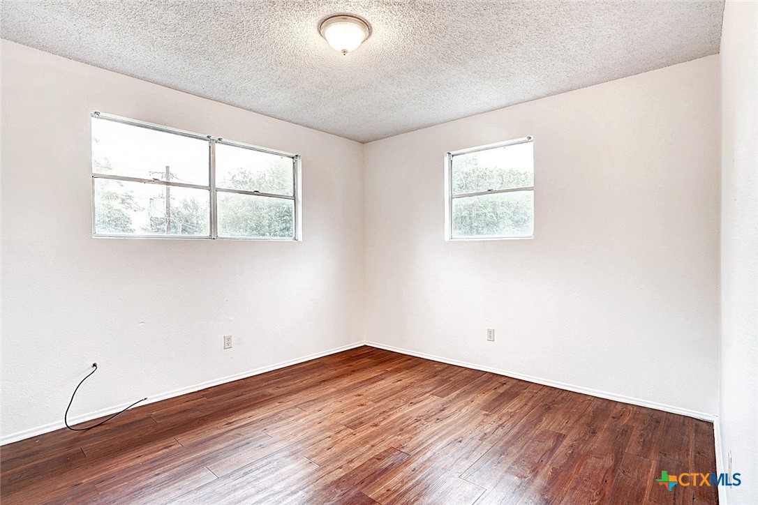 728 Old Martindale Road San Marcos, TX 78666 - Photo 11 of 16 an empty room with wooden floor and windows