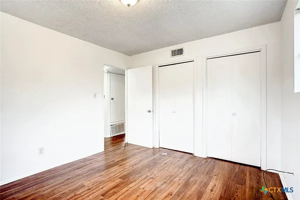 a view of an empty room with wooden floor