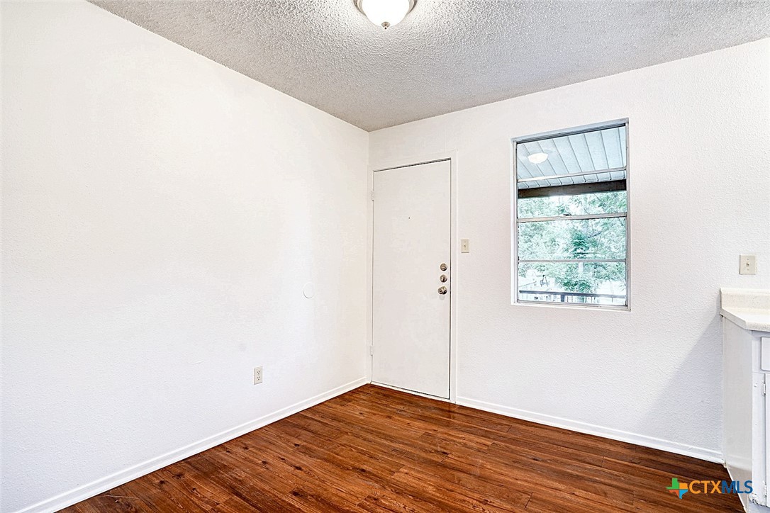 728 Old Martindale Road San Marcos, TX 78666 - Photo 10 of 16 a view of an empty room with wooden floor and a window