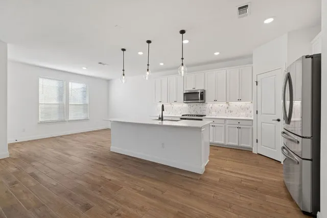 a kitchen with white cabinets and stainless steel appliances