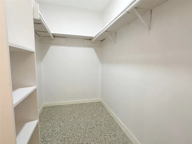 a view of walk in closet with empty racks