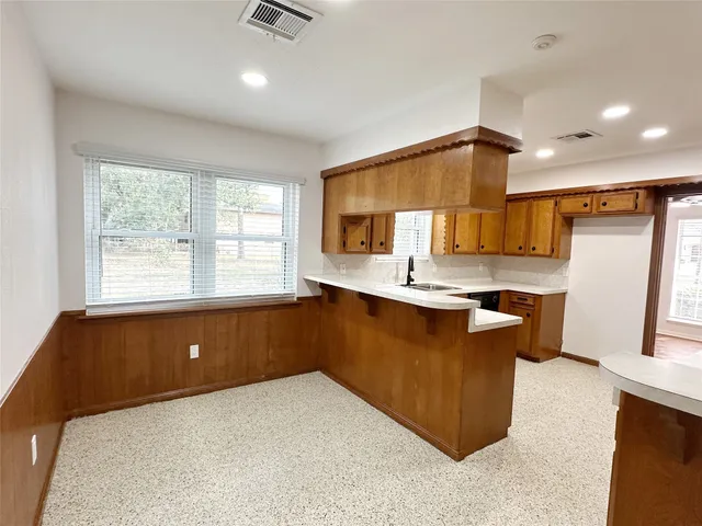 a kitchen with kitchen island granite countertop a sink refrigerator stove and microwave
