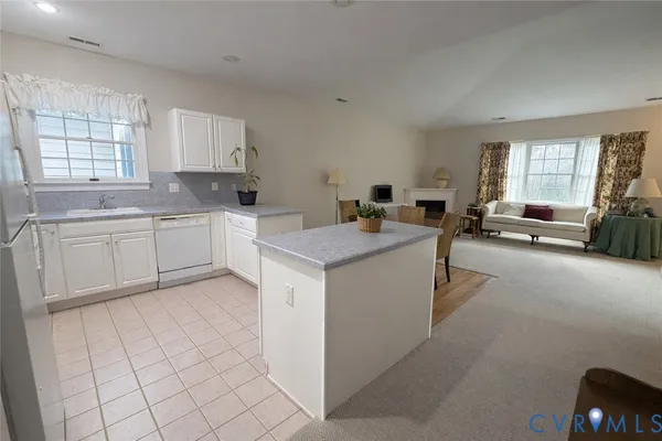 a kitchen with a dining table chairs and refrigerator