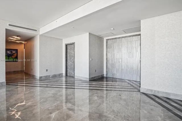 a large white kitchen with kitchen island a sink stainless steel appliances and cabinets