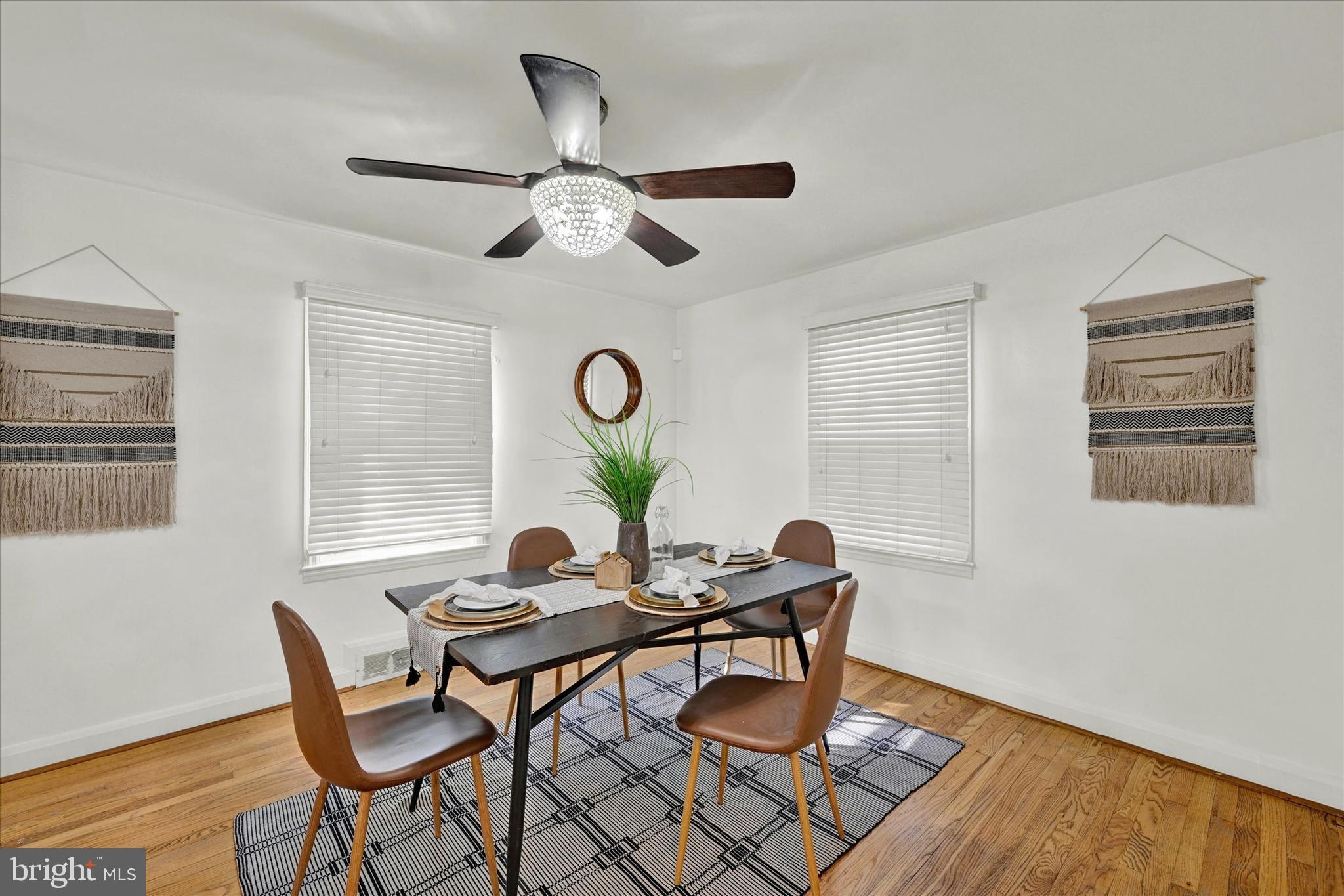 2019 Hillcrest Road Gwynn Oak, MD 21207 - Photo 7 of 29 a dining room with wooden floor a chandelier fan a wooden table and chairs