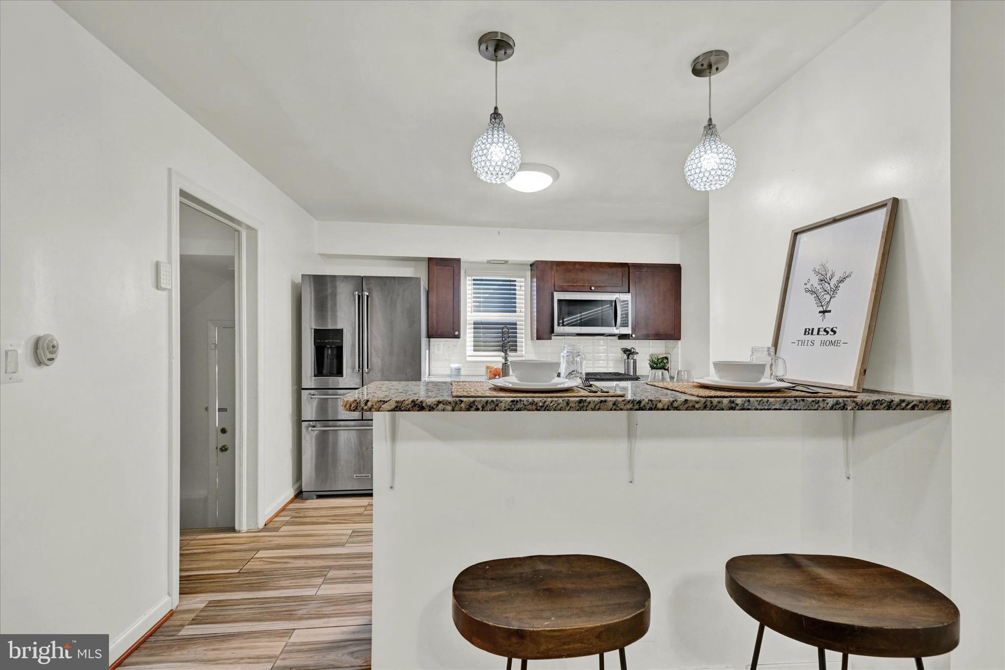 2019 Hillcrest Road Gwynn Oak, MD 21207 - Photo 9 of 29 a kitchen with stainless steel appliances granite countertop a sink a stove cabinets and a dining table