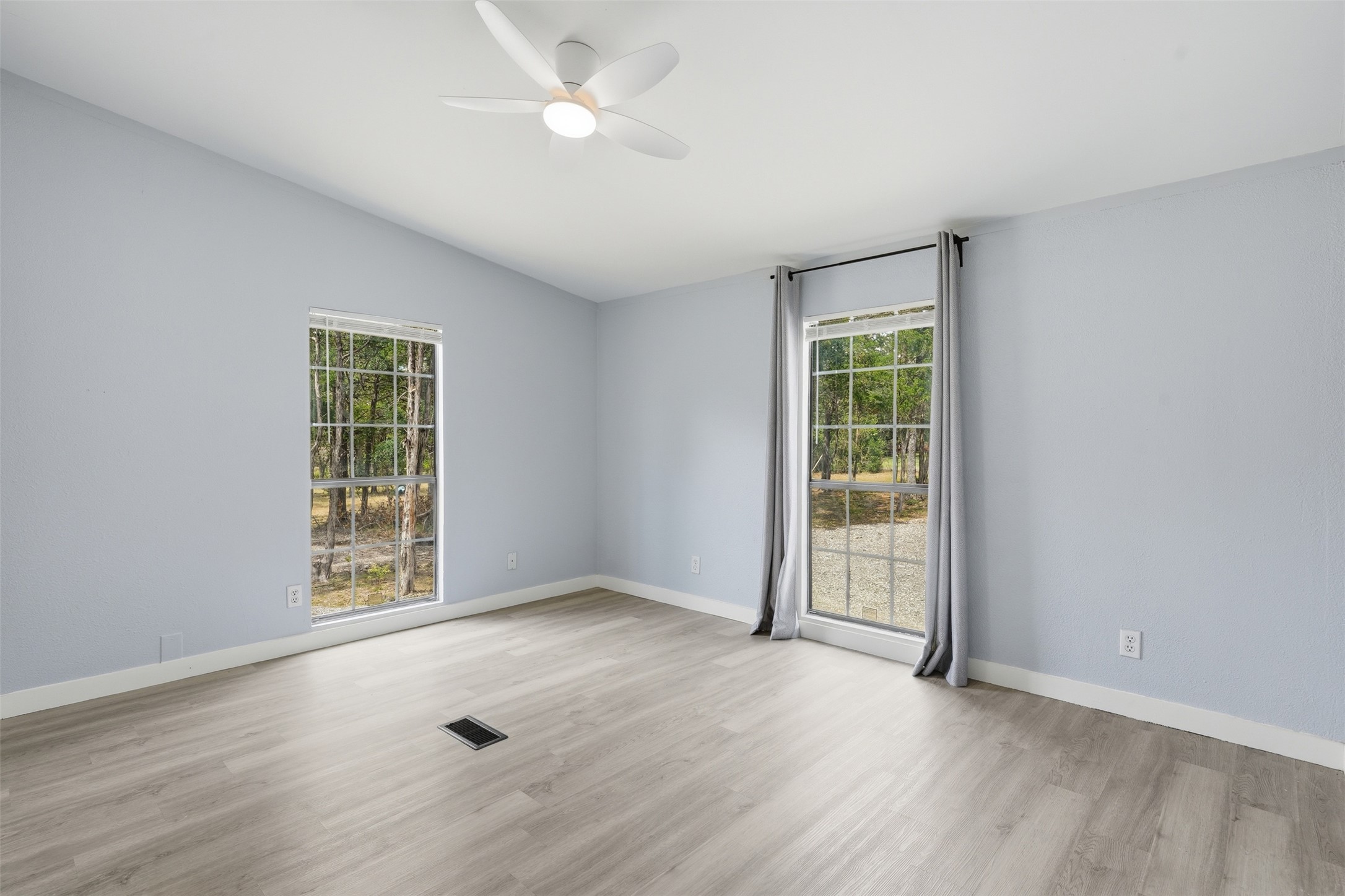 154 Antioch Road Smithville, TX 78957 - Photo 20 of 32 A well-lit bedroom features durable laminate flooring and views of mature trees.