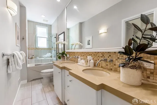 a bathroom with a sink a toilet and a mirror