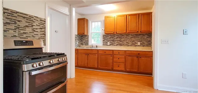 a kitchen with wooden cabinets and a stove top oven
