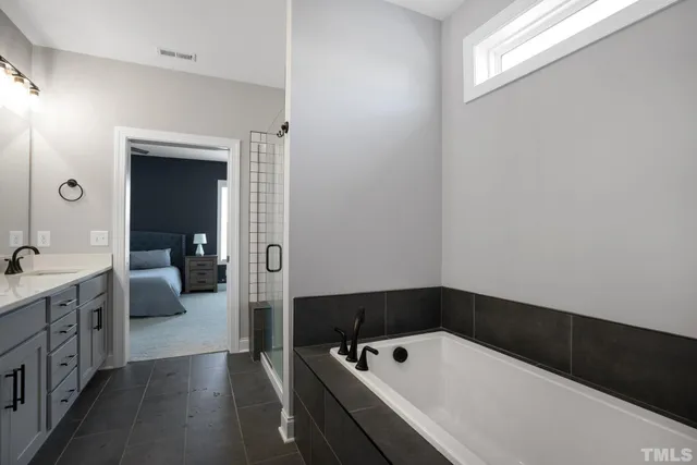 a bathroom with a tub a sink and mirrors