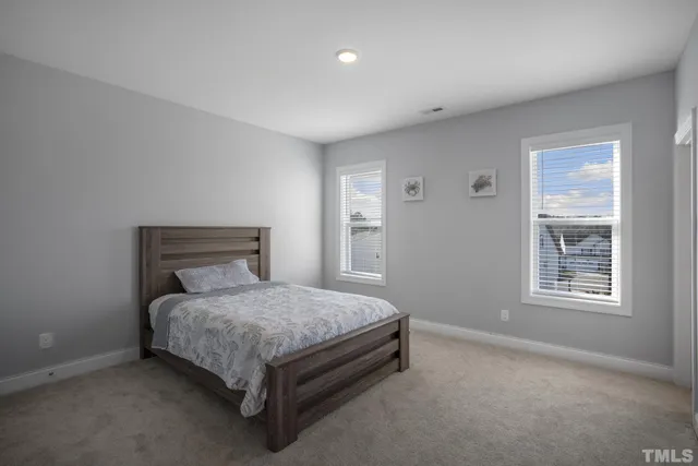 a bed sitting in a bedroom next to a window