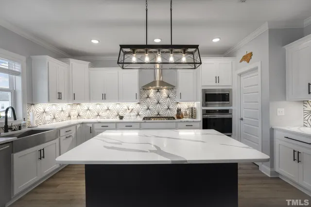 a kitchen with kitchen island granite countertop a sink stove and refrigerator