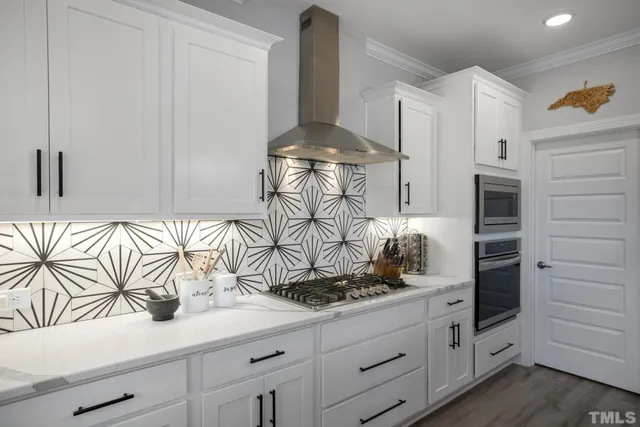a kitchen with white cabinets and appliances