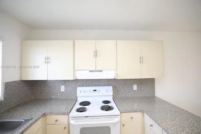 a kitchen with a cabinets and white stove top oven