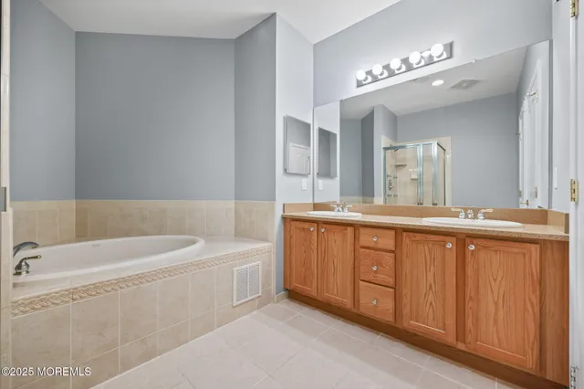 a bathroom with a tub a sink and mirror