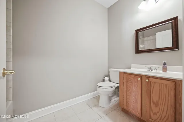 a bathroom with a toilet sink vanity and mirror