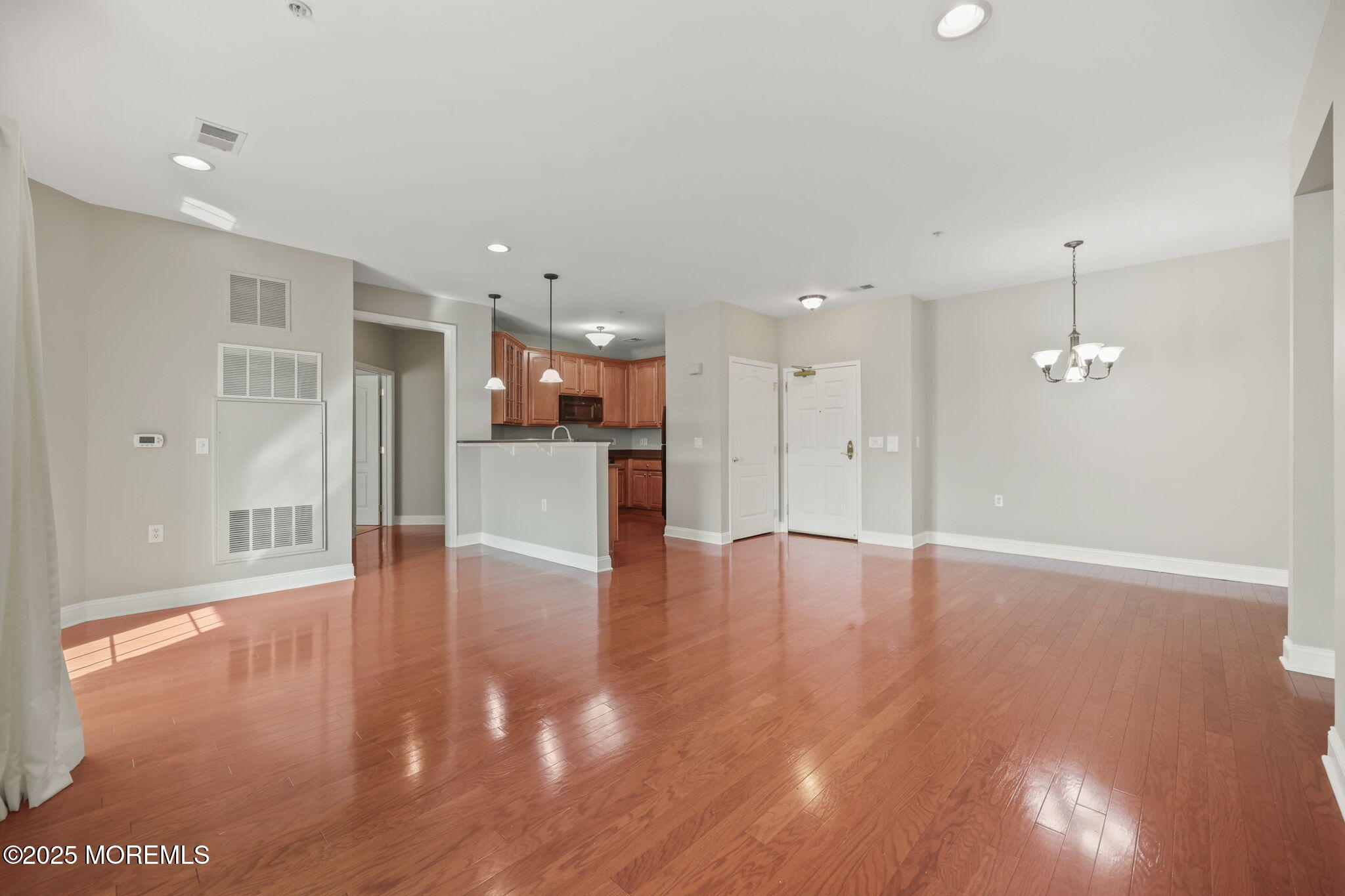 3208 Falston Circle, Unit 3208 Old Bridge, NJ 08857 - Photo 8 of 39 a view of an empty room with wooden floor and a kitchen