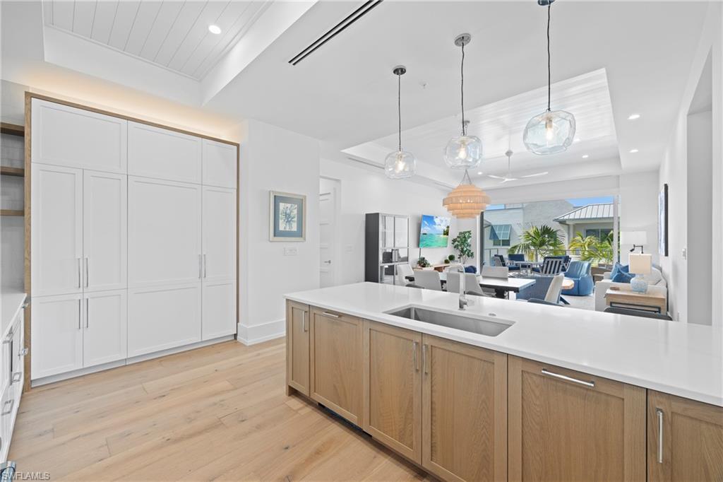 201 8th Street South, Unit 310 Naples, FL 34102 - Photo 12 of 40 a view of a kitchen with a sink and wooden floor