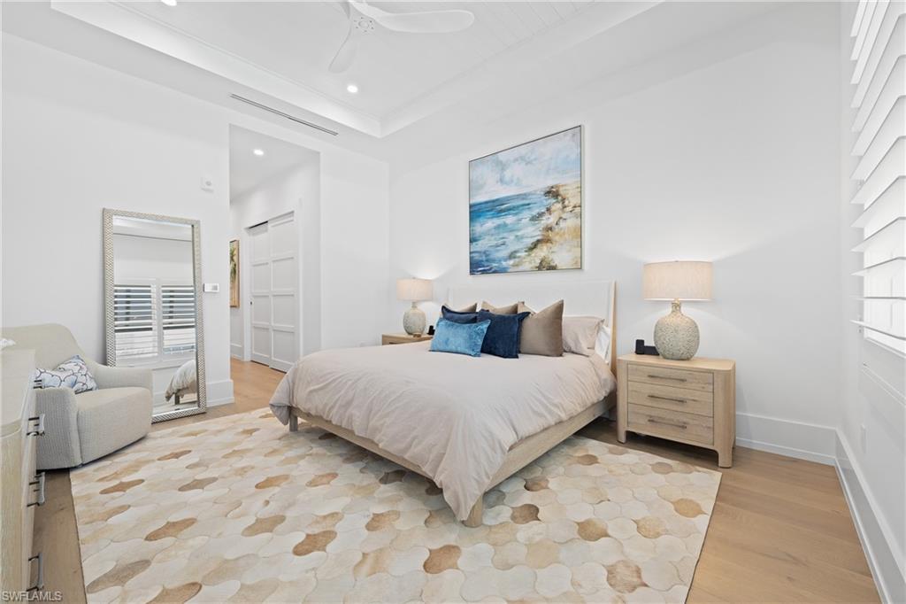 201 8th Street South, Unit 310 Naples, FL 34102 - Photo 14 of 40 a bedroom with a bed and wooden floor