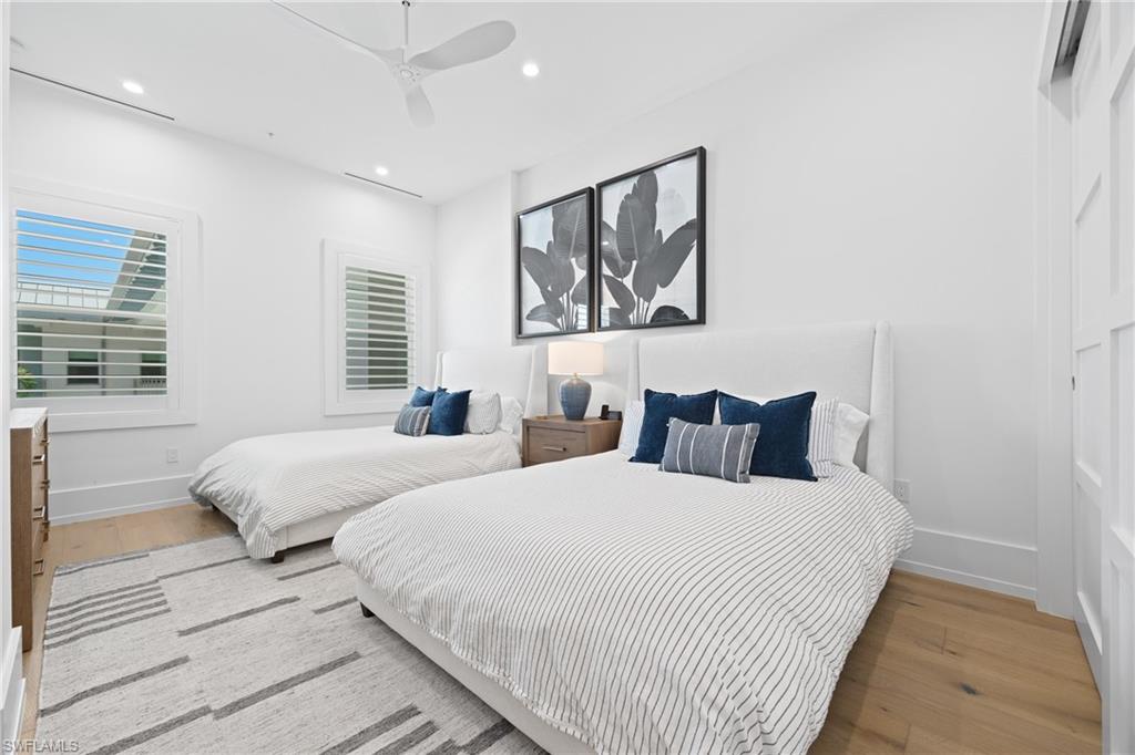 201 8th Street South, Unit 310 Naples, FL 34102 - Photo 18 of 40 a bedroom with two beds and a large window