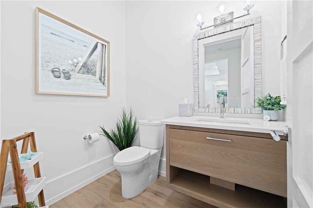 201 8th Street South, Unit 310 Naples, FL 34102 - Photo 22 of 40 a bathroom with a sink a toilet and a mirror