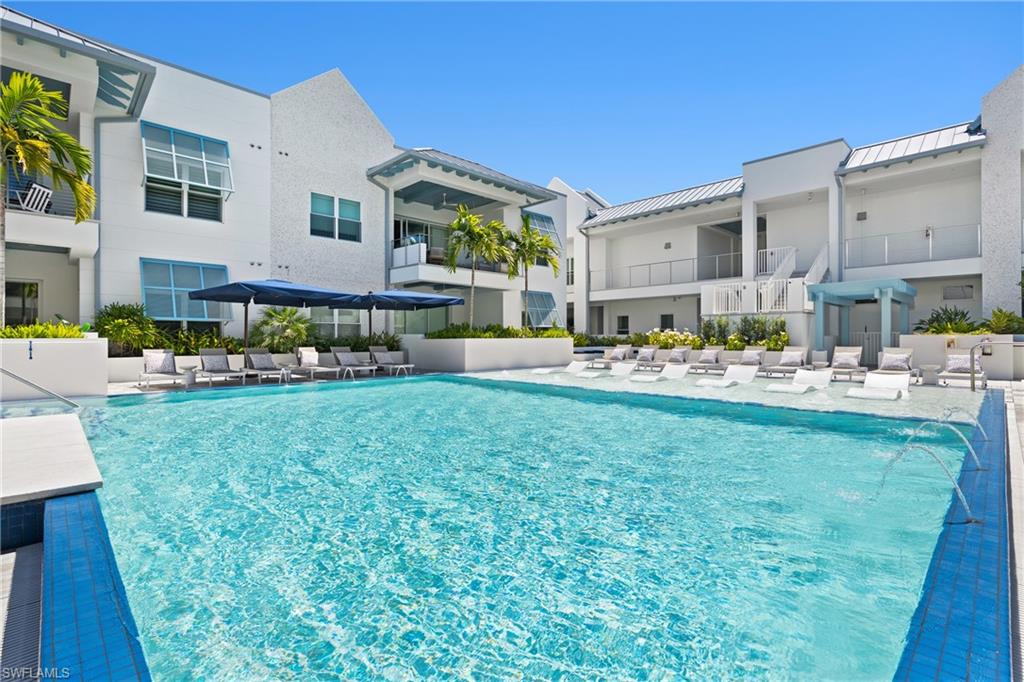 201 8th Street South, Unit 310 Naples, FL 34102 - Photo 28 of 40 a front view of a building with garden and trees