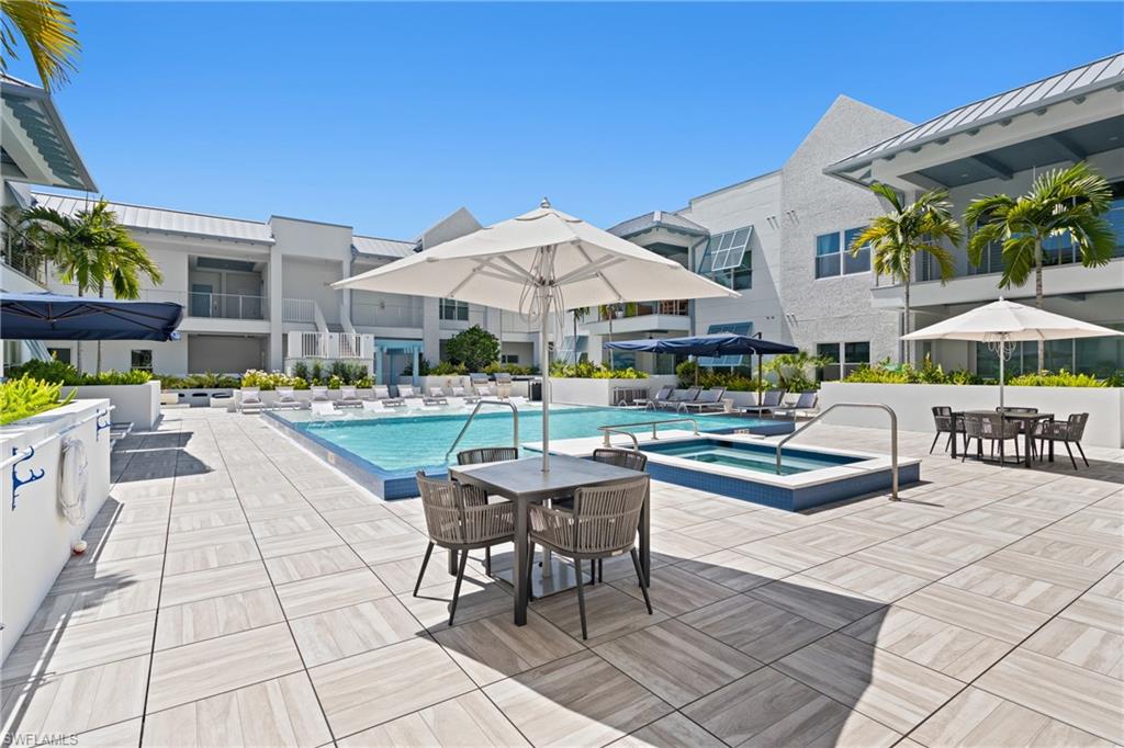 201 8th Street South, Unit 310 Naples, FL 34102 - Photo 30 of 40 a view of a patio with dining table and chairs under an umbrella