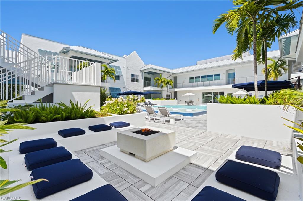 201 8th Street South, Unit 310 Naples, FL 34102 - Photo 32 of 40 a view of a chairs and table in the back yard of the house