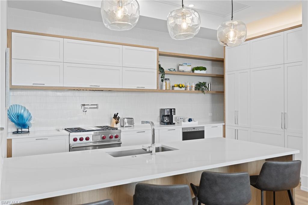 201 8th Street South, Unit 310 Naples, FL 34102 - Photo 10 of 40 a kitchen with a table chairs and chandelier
