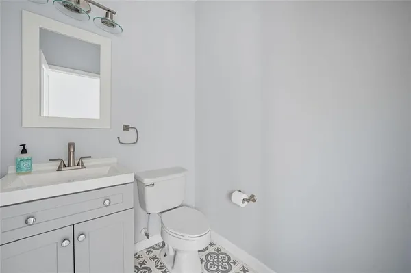 a bathroom with a toilet sink vanity and mirror
