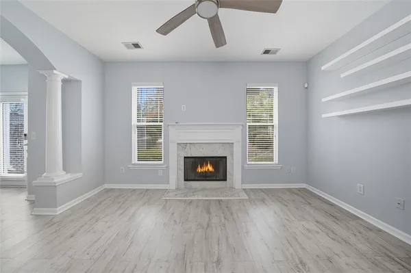 wooden floor fireplace and windows in an empty room