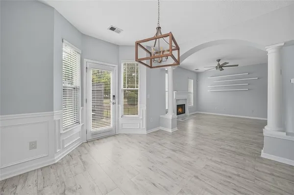 a view of an empty room with a window and wooden floor
