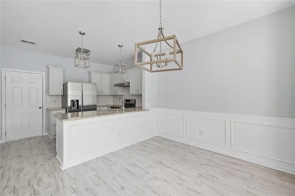 a view of a kitchen with wooden floor and windows