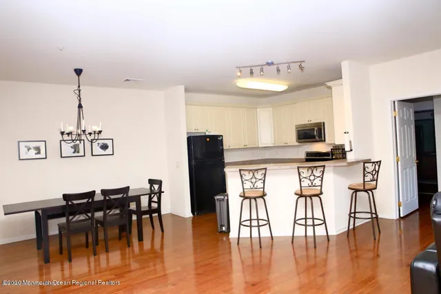 a view of kitchen with refrigerator and wooden floor