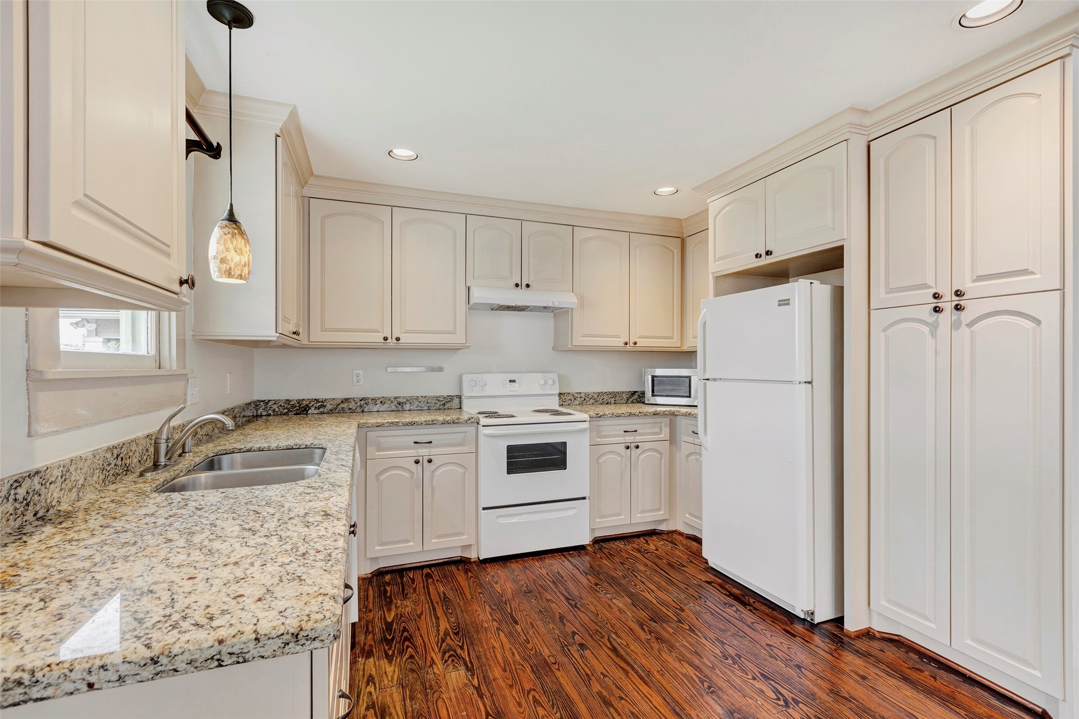 404 East 29th Street Houston, TX 77008 - Photo 2 of 9 a kitchen with a refrigerator stove and white cabinets with wooden floor