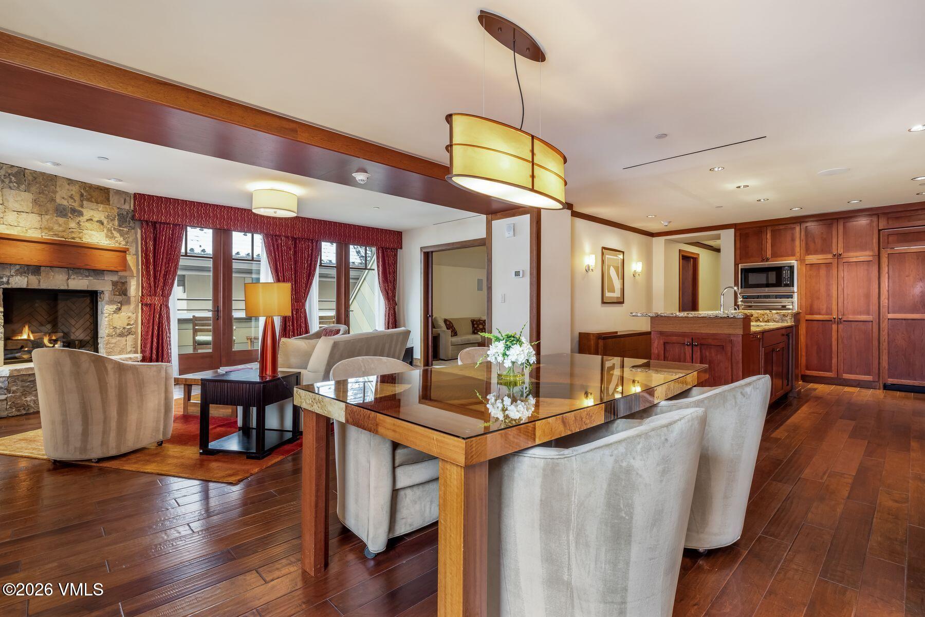 1 Vail Road, Unit 9204 Vail, CO 81657 - Photo 2 of 27 a kitchen with stainless steel appliances granite countertop a refrigerator a oven a dining table and chairs with wooden floor