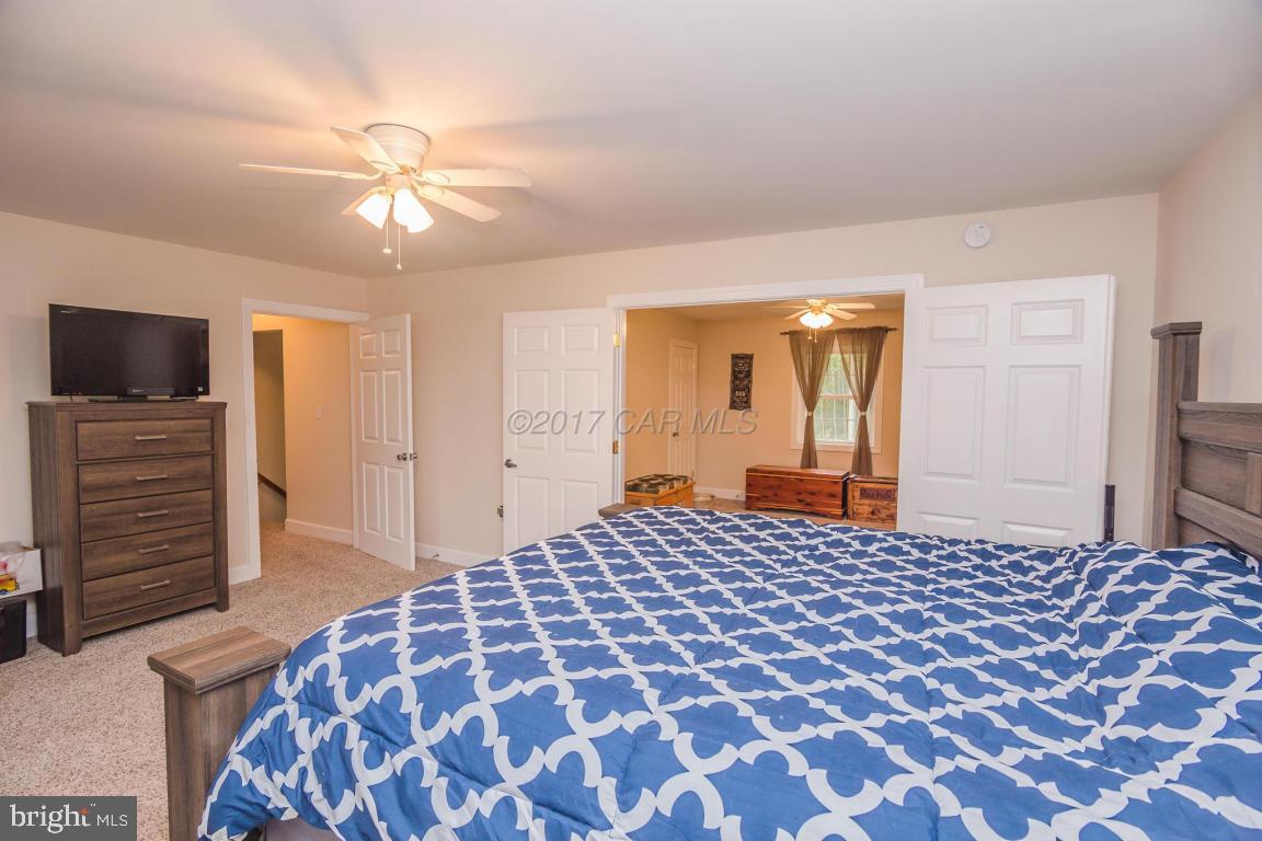 29632 Deal Island Road Princess Anne, MD 21853 - Photo 9 of 33 a bedroom with a bed and a chandelier