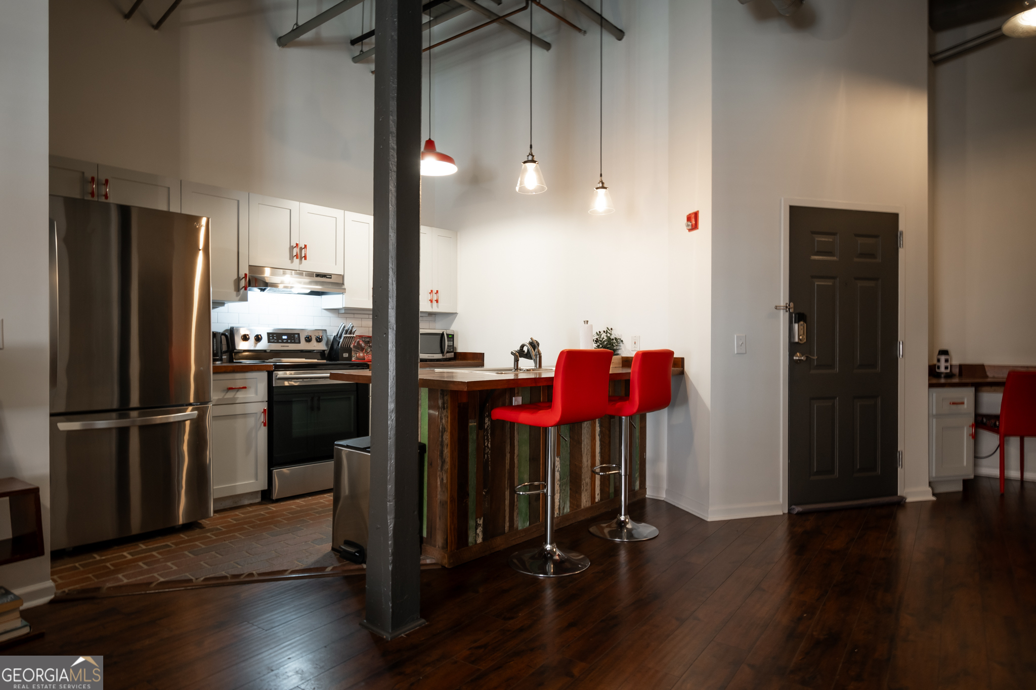 269 North Hull Street, Unit 202 Athens, GA 30601 - Photo 3 of 25 a kitchen with stainless steel appliances granite countertop a refrigerator a stove and a dining table with wooden floor