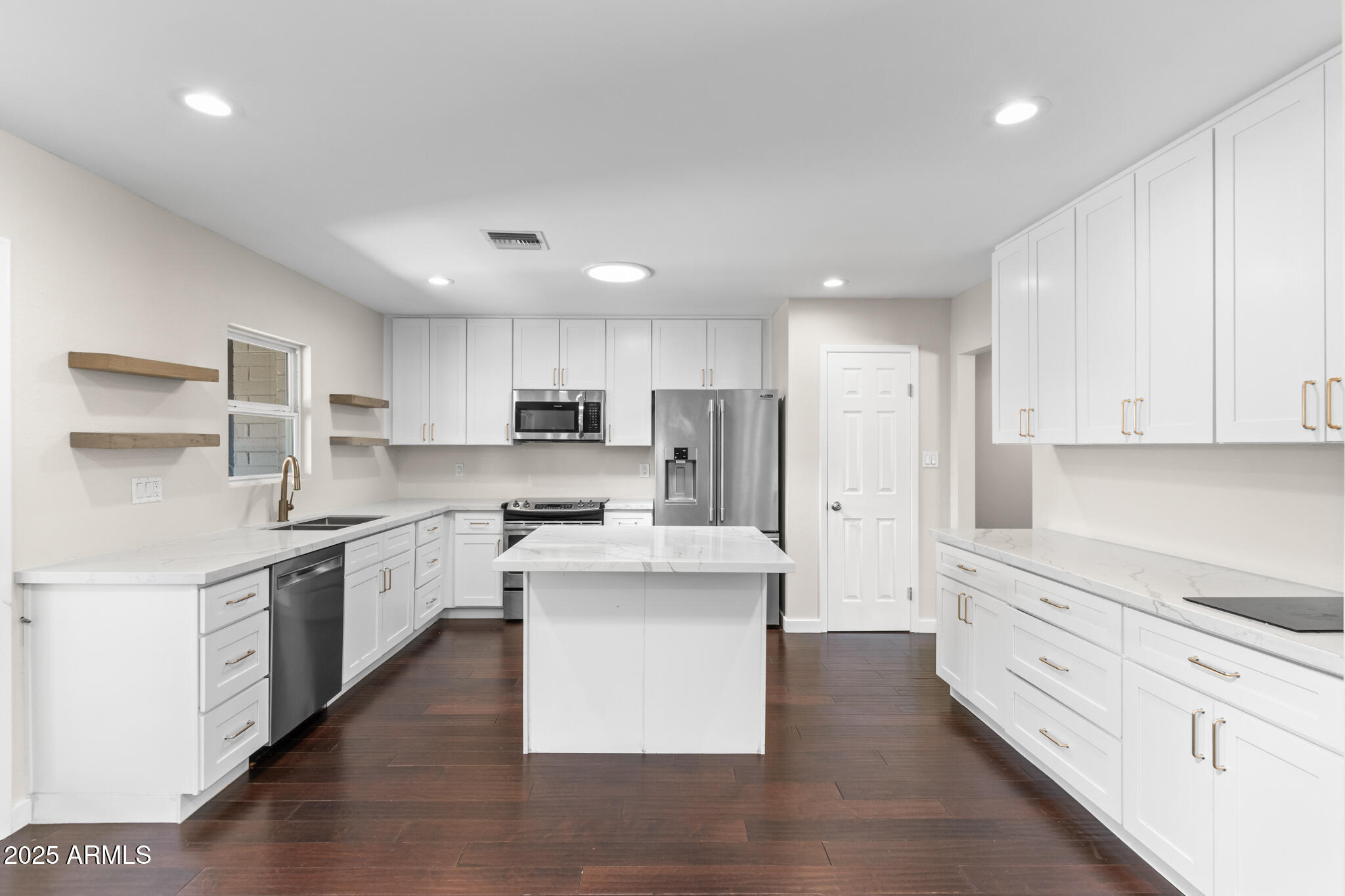 1911 East Lawrence Road Phoenix, AZ 85016 - Photo 16 of 49 a kitchen with stainless steel appliances white cabinets and wooden floors
