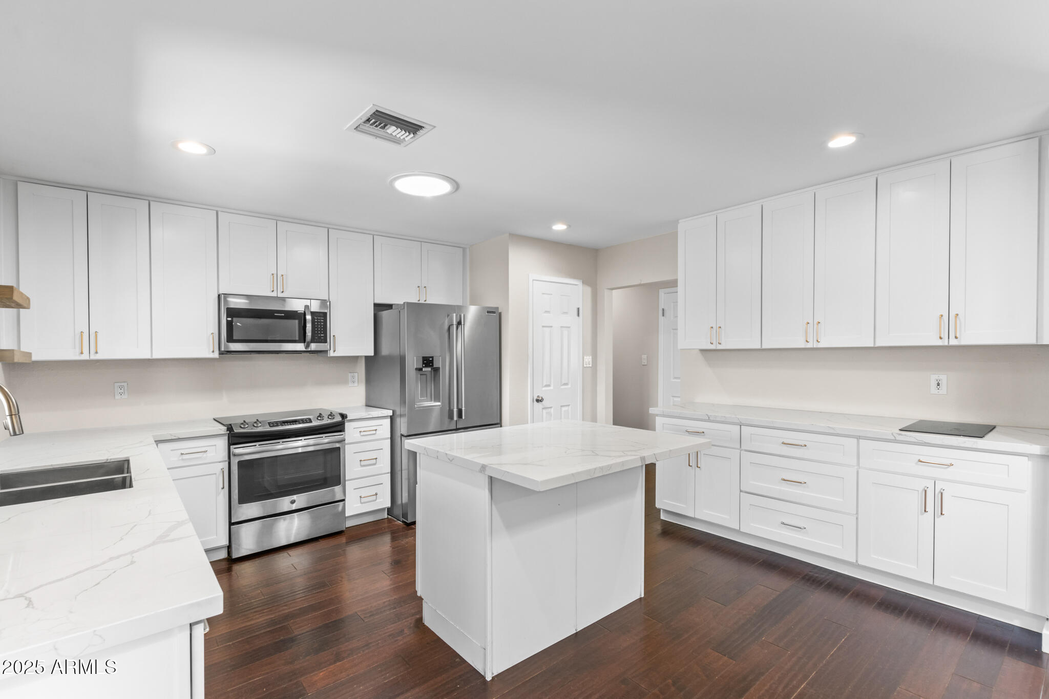 1911 East Lawrence Road Phoenix, AZ 85016 - Photo 18 of 49 a kitchen with white cabinets and stainless steel appliances