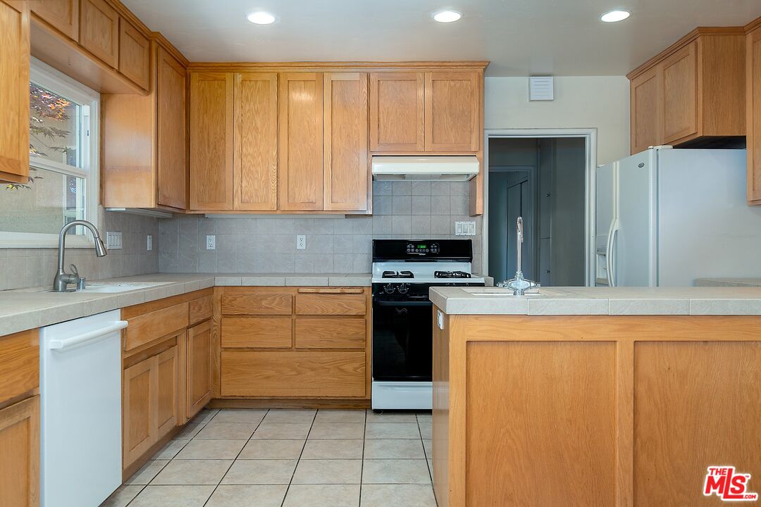 722 South McClelland Street Santa Maria, CA 93454 - Photo 10 of 27 a kitchen with stainless steel appliances granite countertop a stove a sink and a refrigerator