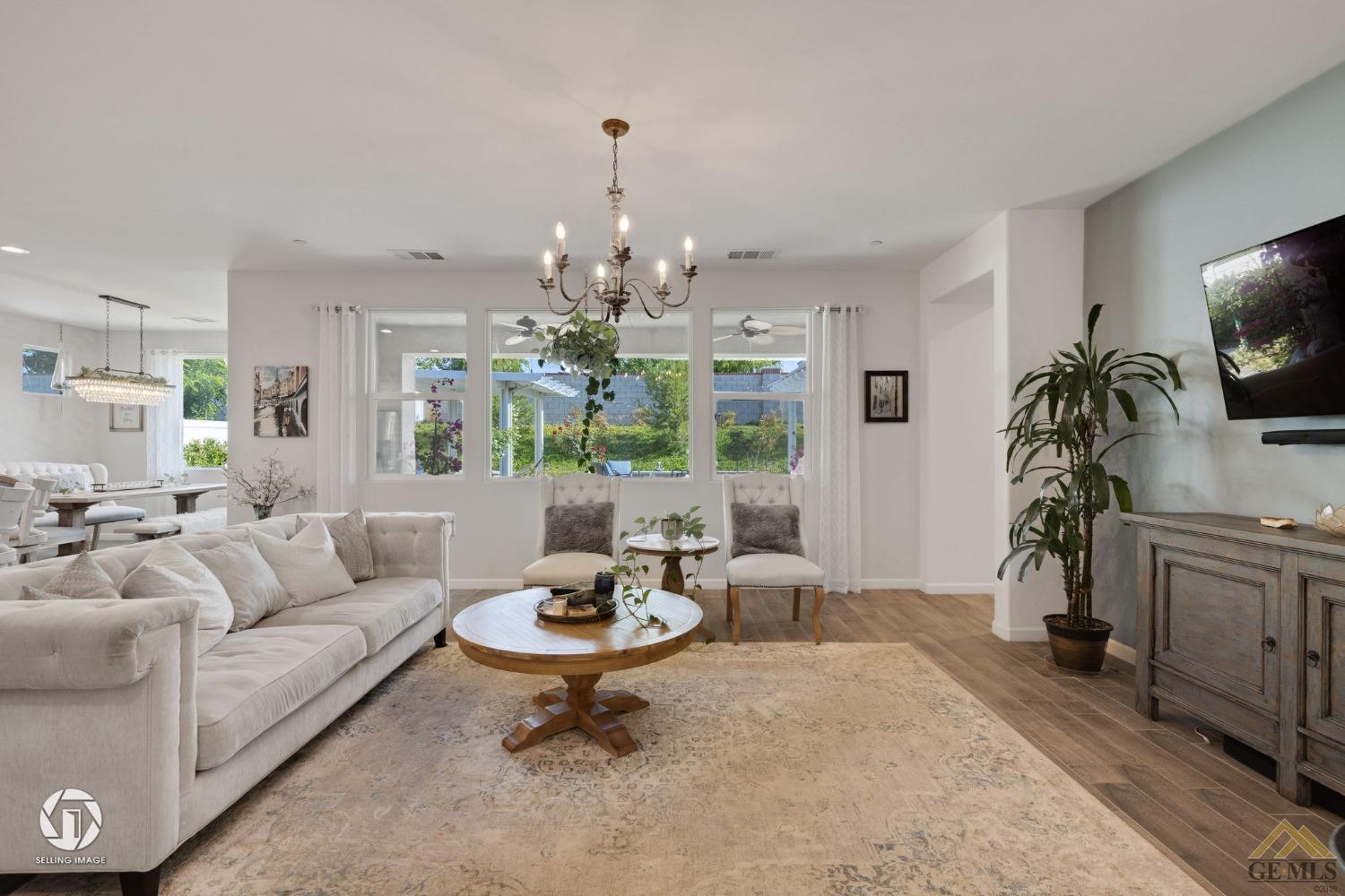 Undisclosed Address Bakersfield, CA 93311 - Photo 13 of 49 a living room with furniture a chandelier and a flat screen tv