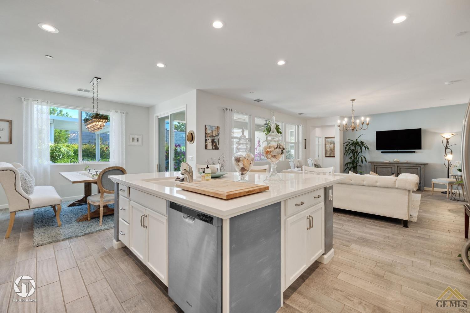 Undisclosed Address Bakersfield, CA 93311 - Photo 18 of 49 a kitchen with sink stove and hall with wooden floor