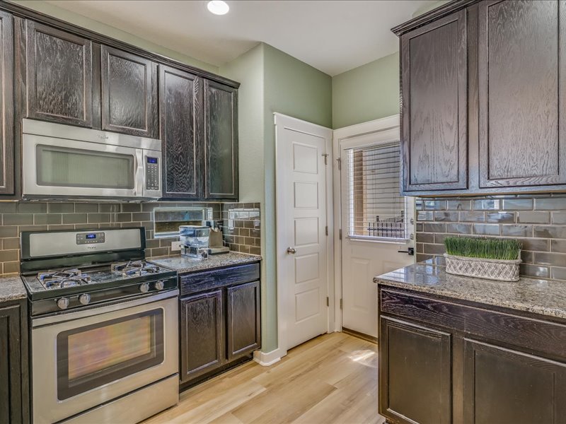 2101 Rivers Edge Way, Unit 29 Austin, TX 78741 - Photo 9 of 34 a kitchen with granite countertop cabinets stainless steel appliances and wooden floor