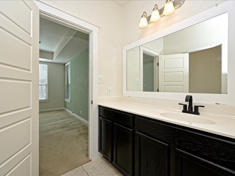 2101 Rivers Edge Way, Unit 29 Austin, TX 78741 - Photo 17 of 34 a bathroom with a sink vanity and mirror