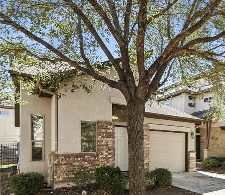 2101 Rivers Edge Way, Unit 29 Austin, TX 78741 - Photo 2 of 34 a tree in front of a white house