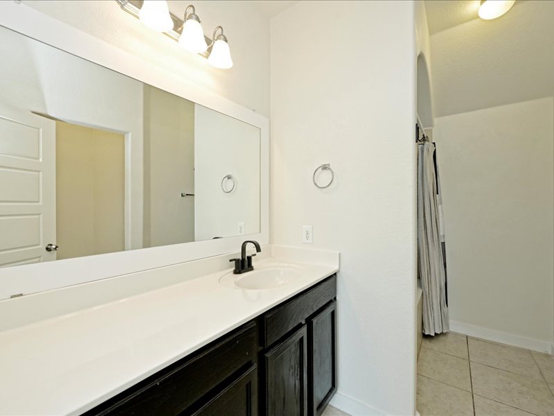 2101 Rivers Edge Way, Unit 29 Austin, TX 78741 - Photo 19 of 34 a bathroom with a sink and a mirror