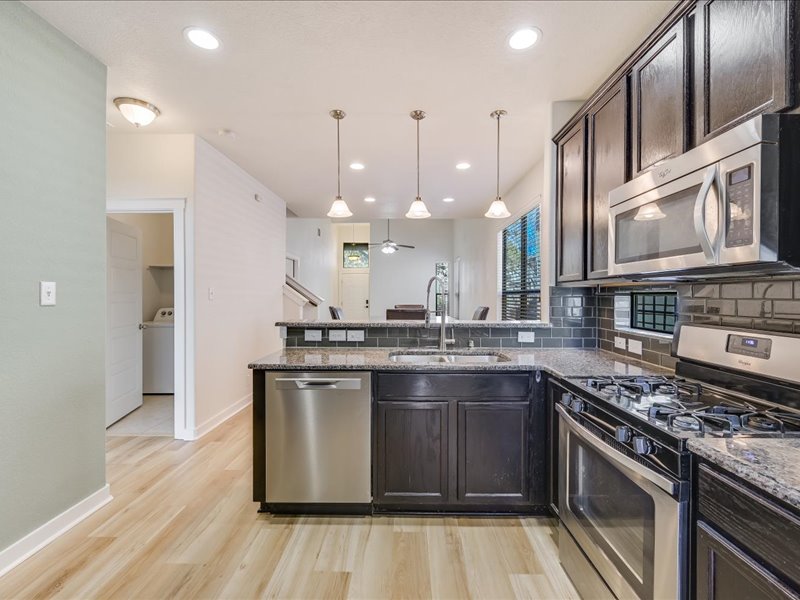 2101 Rivers Edge Way, Unit 29 Austin, TX 78741 - Photo 6 of 34 a kitchen with stainless steel appliances granite countertop a stove and a sink